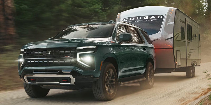 2026 Chevy Tahoe towing a boat — demonstrating 8,400-lb towing capacity