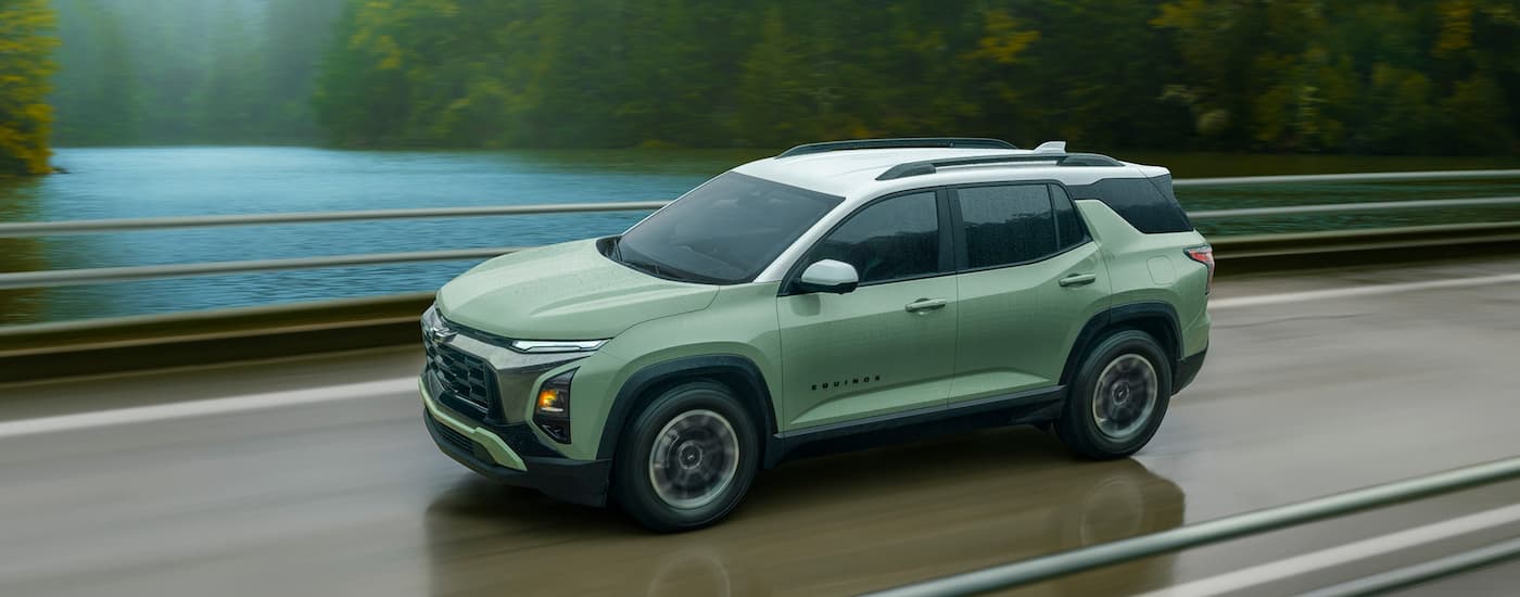 Green 2026 Chevy Equinox driving across a bridge.