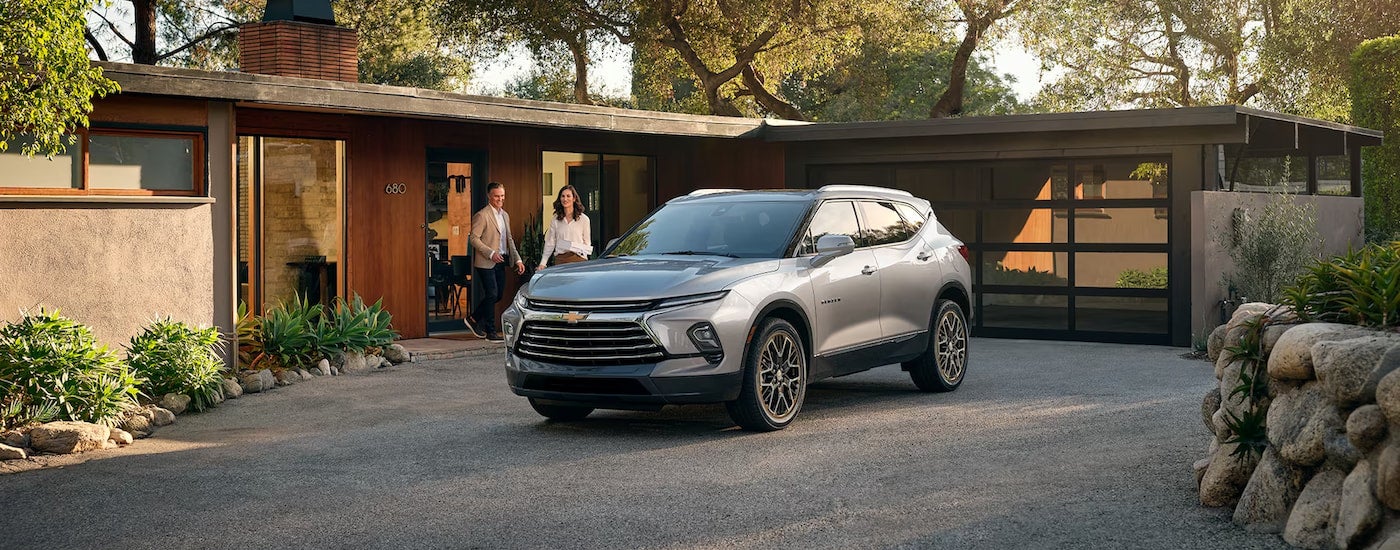 A silver 2024 Chevy Blazer Premier parked in the driveway of a modern home.