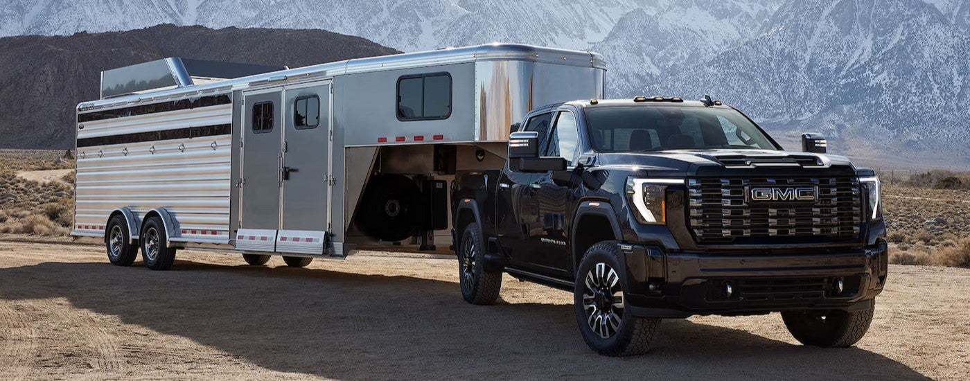 A black 2025 GMC Sierra 3500 HD towing a trailer.
