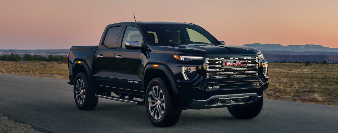 Black 2025 GMC Canyon driving at dusk